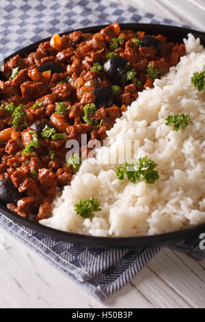 Cuban food: Picadillo a la habanera with a side dish of rice close-up on a plate. Vertical Stock Photo