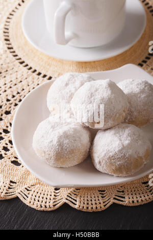 American cookies polvoron with powdered sugar close-up on a plate. vertical Stock Photo
