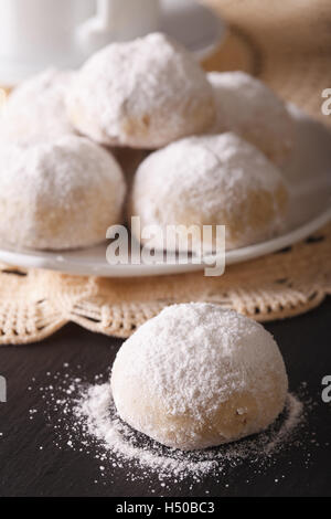 Traditional Mexican polvoron cookies with pecans and powdered sugar macro on the table. vertical Stock Photo