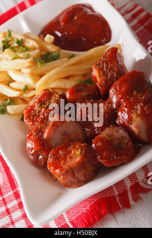 German cuisine: currywurst with french fries close-up on a plate. vertical Stock Photo