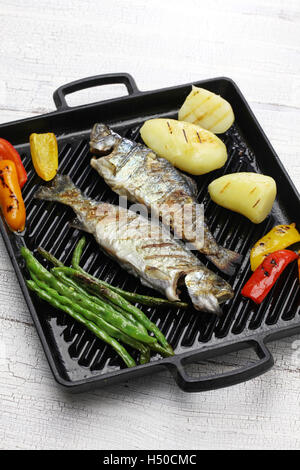 grilled whole rainbow trout with vegetables on grill pan Stock Photo