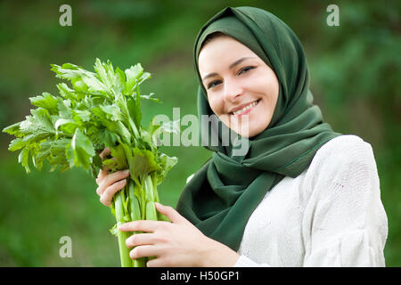 Muslim Vegan Woman with Veil Holding a Celery Stock Photo