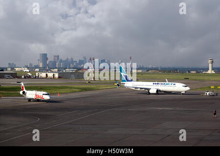 Calgary, Canada - July 18, 2014: Two commercial airliners sit on the tarmac of Calgary International Airport YYC. Stock Photo