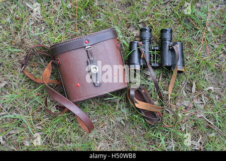 old pair of binoculars with the cover on the grass Stock Photo