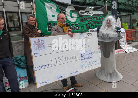 London, UK. 19th October 2016. A woman dressed as a cooling tower at the protest by the Axe Drax campaign on the International Day of Action on Biomass outside the new Dept of Business Energy and Industrial Strategy is presented with a cheque for  the government subsidy in 2015 of £450m. Protesters urge the government to acknowledge the scientific research that shows that producing electricity from Biofuels is harmful to the climate, forests, biodiversity and people and remove the subsidy which encourages its use. Peter Marshall/Alamy Live News Stock Photo