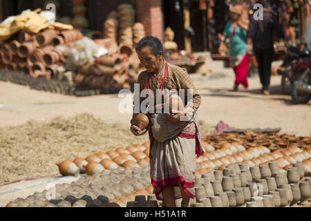Bhaktapur, Nepal. 19th Oct, 2016. A Nepalese woman works at the pottery square in Bhaktapur, Nepal, Oct. 19, 2016. Bhaktapur is an ancient Newar community town and is well known for its pottery work. © Pratap Thapa/Xinhua/Alamy Live News Stock Photo