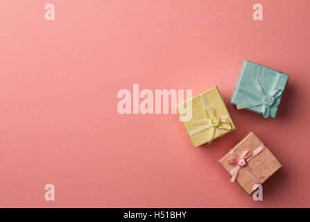 Top view of three small cardboard rectangular gift boxes on red paper background with copy space Stock Photo