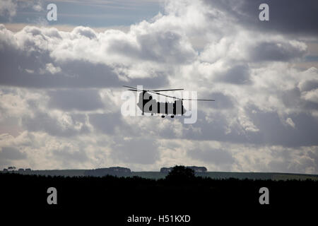 A Chinook HC4 operated by 28 Squadron RAF Benson, Oxfordshire, UK flies over farmland in West Hanney, Oxfordshire, UK Stock Photo