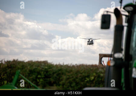 A Chinook HC4 operated by 28 Squadron RAF Benson, Oxfordshire, UK flies over farmland in West Hanney, Oxfordshire, UK Stock Photo