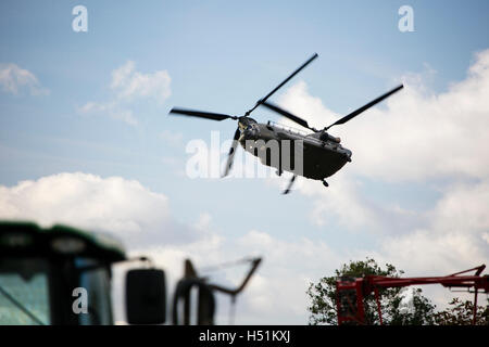 A Chinook HC4 operated by 28 Squadron RAF Benson, Oxfordshire, UK flies over farmland in West Hanney, Oxfordshire, UK Stock Photo