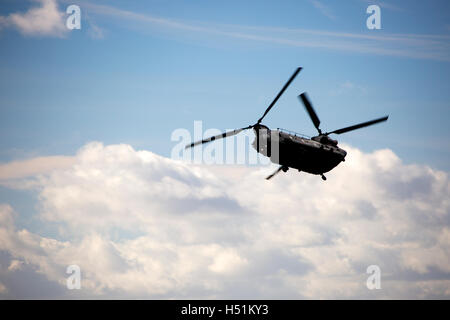 A Chinook HC4 operated by 28 Squadron RAF Benson, Oxfordshire, UK flies over farmland in West Hanney, Oxfordshire, UK Stock Photo