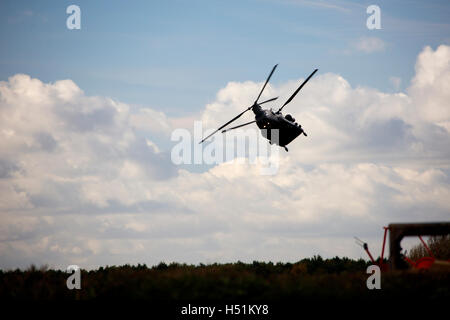 A Chinook HC4 operated by 28 Squadron RAF Benson, Oxfordshire, UK flies over farmland in West Hanney, Oxfordshire, UK Stock Photo