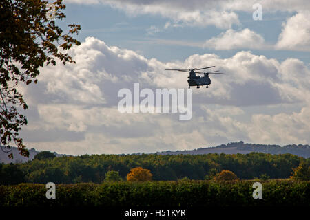 A Chinook HC4 operated by 28 Squadron RAF Benson, Oxfordshire, UK flies over farmland in West Hanney, Oxfordshire, UK Stock Photo