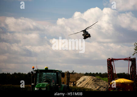 A Chinook HC4 operated by 28 Squadron RAF Benson, Oxfordshire, UK flies over farmland in West Hanney, Oxfordshire, UK Stock Photo