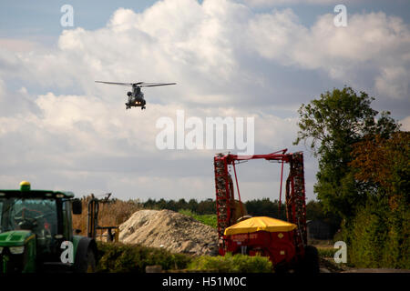 A Chinook HC4 operated by 28 Squadron RAF Benson, Oxfordshire, UK flies over farmland in West Hanney, Oxfordshire, UK Stock Photo