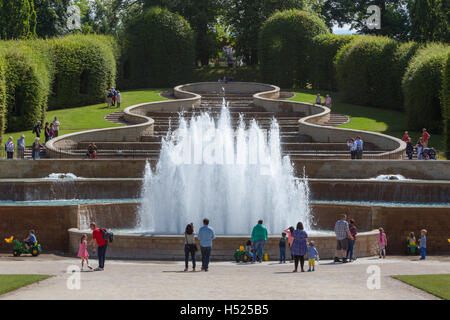 Cascade waterfall at Alnwick Garden in Northumberland on a summer's day with families gathered around Stock Photo
