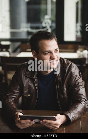 Young man or student using tablet computer in cafe Stock Photo