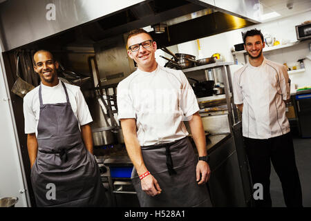 Portrait of three chefs in a restaurant kitchen. Stock Photo
