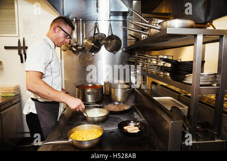 Chef cooking in a restaurant kitchen. Stock Photo