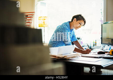 Woman working at a desk in interior design studio and accessories store. Stock Photo