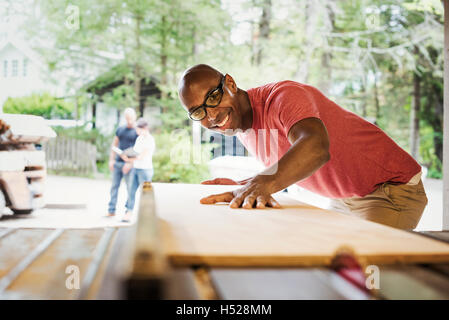 Man wearing glasses working in a lumber yard. Stock Photo