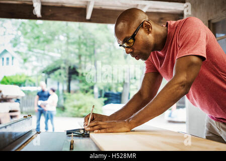 Man wearing glasses working in a lumber yard. Stock Photo