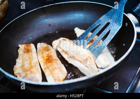 Close up of fish fillets being fried in a frying pan. Stock Photo
