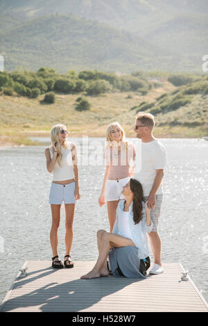 Man, woman and their two blond daughters on a jetty. Stock Photo
