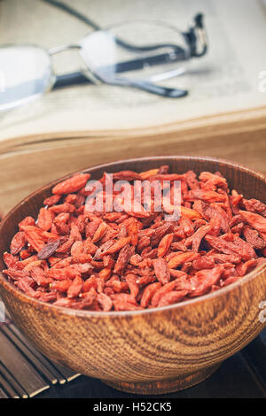 Dried goji berries in wooden bowl as a healthy snack Stock Photo