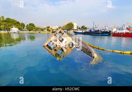 sunken boat reflected on water at Eleusis Greece Stock Photo