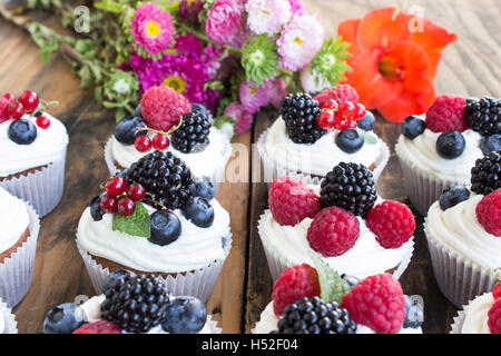 Cupcakes with Fruits on a Rustic Wooden Table. Stock Photo