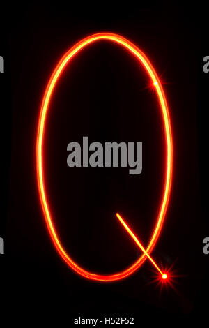 red thin light painting letter Q on black background Stock Photo