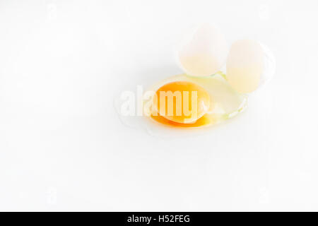 white egg is broken and leaked on a white background.. Stock Photo