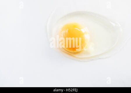 white egg is broken and leaked on a white background.. Stock Photo