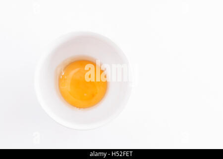 raw egg yolk in a bowl on a white background. Stock Photo