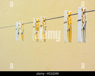 Plastic clothespins on yellow background Stock Photo