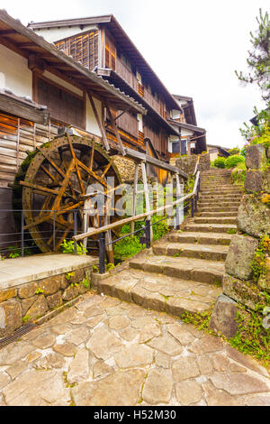 Stone steps next to traditional waterwheel in historic restored town of Magome on the ancient Nakasendo trail on an overcast day Stock Photo