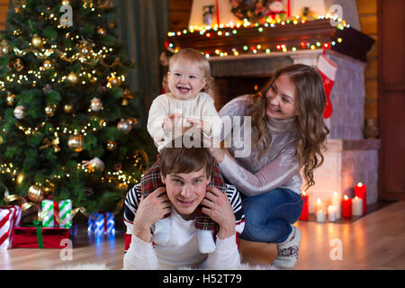 christmas, x-mas, family, people, happiness concept - happy parents playing with pretty baby boy Stock Photo