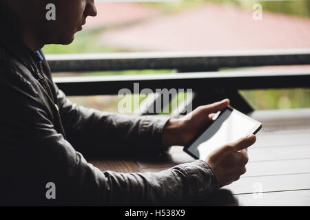 checking email on touchpad, close up of hands using digital tablet in cafe Stock Photo