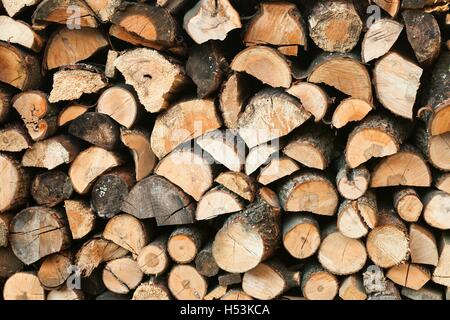 Stack of chopped firewoods prepared for winter. Wooden background Stock Photo