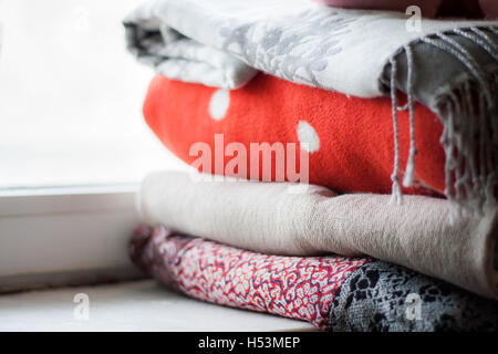 a stack of plaids on the windowsill. Stock Photo