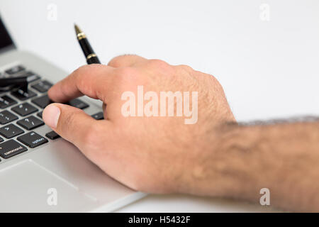 man holding a black pen and working on a laptop. shot on a white background Stock Photo
