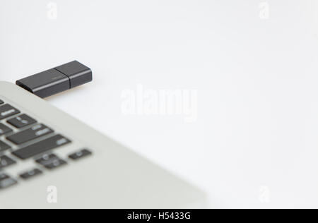 a 16gb black usb stick plugged on right side of a laptop. closeup shot with focus on keyboard and usb stick Stock Photo