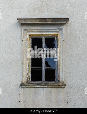 Vandalized window on a building with bullet marks. Stock Photo