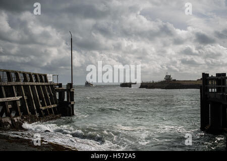 Dramatic clouds fill the sky as a ship leaves Shoreham Port in Shoreham By Sea, West Sussex, England. Stock Photo