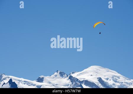 Paragliding flying over Mont Blanc Massif, in the background is Mont Blanc peak, Alps, Chamonix, France Stock Photo
