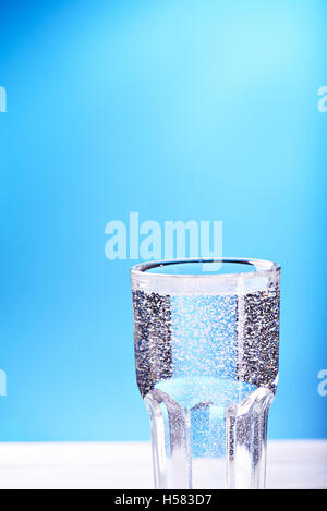 water in glass with bubbles at a blue background Stock Photo