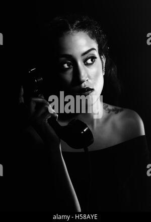 Black and white portrait of a British Asian woman on a vintage telephone Stock Photo