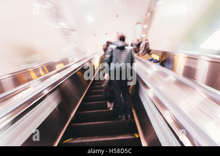 Moton blurred commuters on escalator. Stock Photo