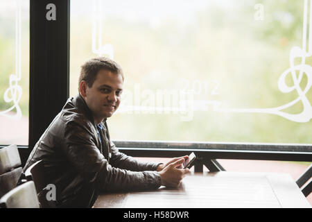 Young man sit in the city cafe during lunch time and working on tablet Stock Photo
